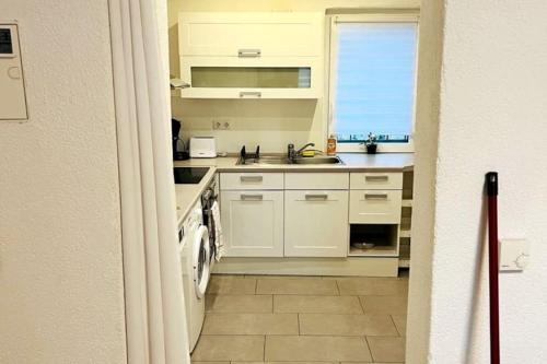 a kitchen with white cabinets and a sink and a window at Helle 1,5 Zimmer Wohnung in Höchberg