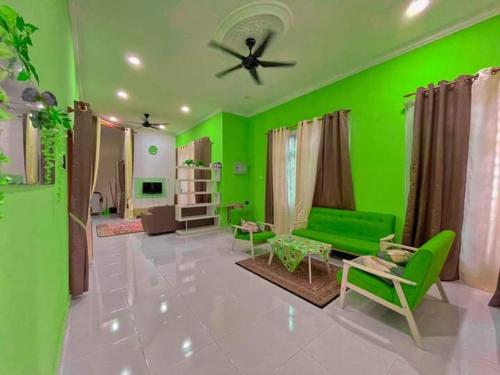 a green living room with a green wall at Airport Kelantan HOMESTAY & TRANSIT ROOM in Kota Bharu