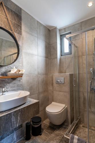 a bathroom with a sink and a toilet and a shower at Olympus Pantheon Luxury Rooms in Plaka Litochorou