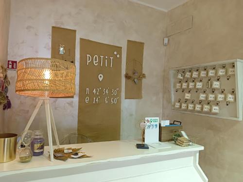 Zimmer mit einem Tisch, einer Lampe und einem Spiegel in der Unterkunft Hotel Petit in Silvi Marina