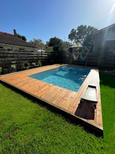 une grande piscine avec une terrasse en bois dans l'établissement Beach house idéale pour famille, 400 m de l’océan, à Labenne