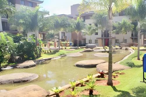 a garden with a pond in a building at OZPED Flats Particulares Edifício Life Resort in Brasilia