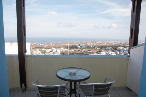 a table and chairs on a balcony with a view at Villa Stella in Fira