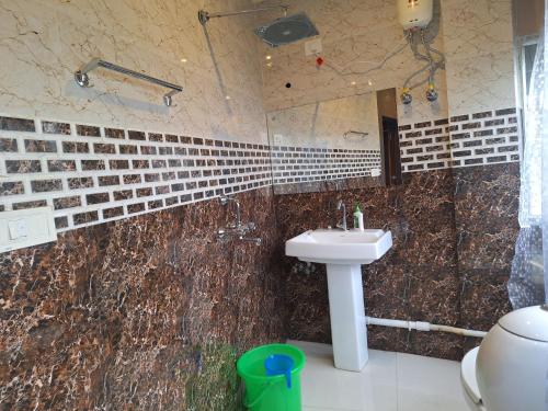 y baño con lavabo y ducha. en Mavenoak Dreams B&B, en Calcuta