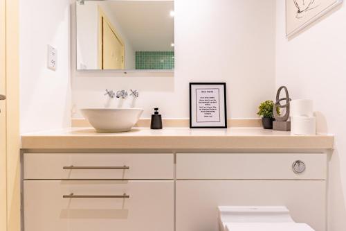 a bathroom with a sink and a bowl on a counter at Birmingham City Centre Apartment in Birmingham