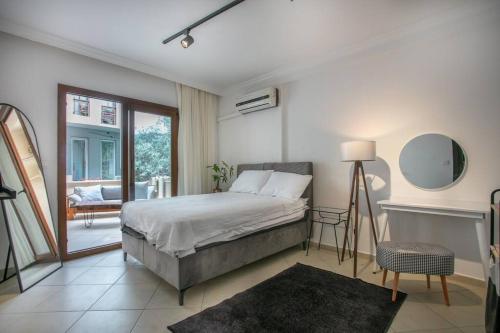 1 dormitorio con cama y vistas a un balcón en flaneur home en Marmaris