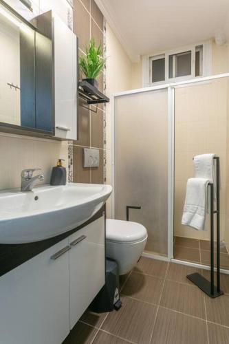 een badkamer met een witte wastafel en een toilet bij flaneur home in Marmaris
