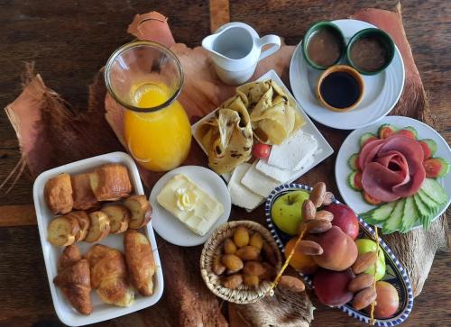 una tavola ricoperta di piatti di cibo e un bicchiere di succo d'arancia di Villa Taouzert a Tozeur