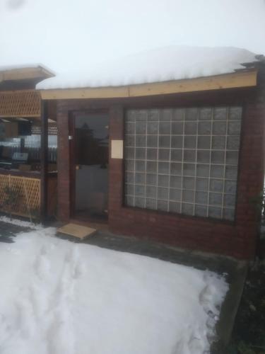 a building with snow in front of it at Riverside • cabine in Gălăuţaş