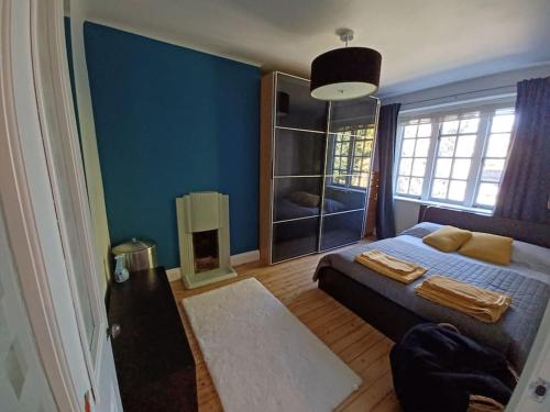 a bedroom with a bed and a blue wall at The Gem - central character flat with parking in Southampton