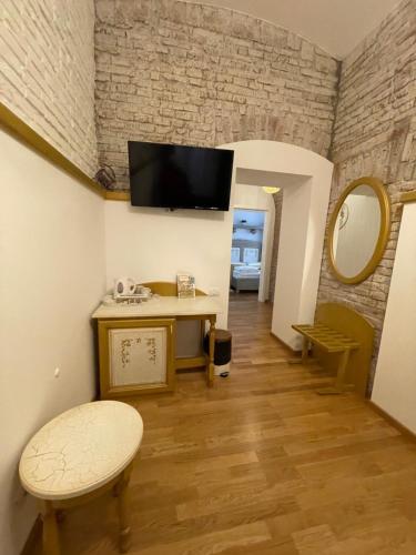 a room with a desk and a tv on a brick wall at Casa Lais in Braşov