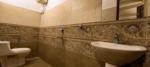 La salle de bains est pourvue d'un lavabo et de toilettes. dans l'établissement Hotel Grace Ganga, à Rishikesh
