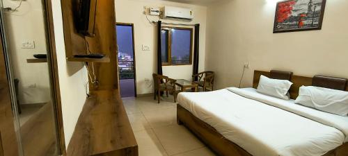 sypialnia z 2 łóżkami, stołem i krzesłami w obiekcie Hotel Grace Ganga w mieście Rishikesh