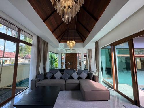 a living room with a couch and a chandelier at Ocean Palms Luxury Villa Bangtao Beach Phuket in Bang Tao Beach