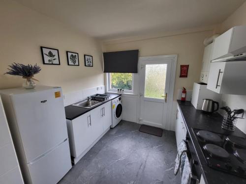 a kitchen with a white refrigerator and a sink at Large 3 bed, great for contractors, with private parking in Provanmill