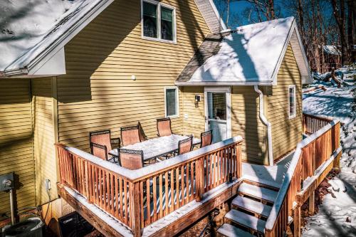 a house with a wooden deck with chairs on it at Mt Views - Sauna - Hot Tub - Adulting - Family Fun in Massanutten