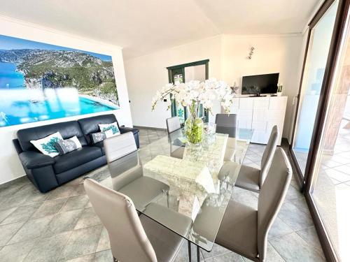 a living room with a glass table and a couch at Cala Gonone house in Cala Gonone