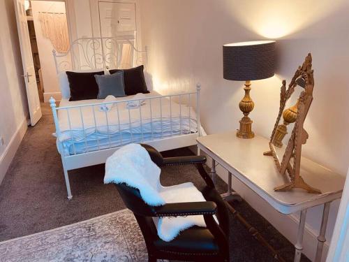 ブライトン＆ホーブにあるSeaside Getawayの白いベッド、テーブル、椅子が備わる客室です。