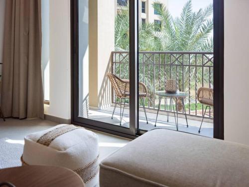 Post Modern Near Burj Al Arab في دبي: غرفة معيشة مع شرفة مع طاولة وكراسي