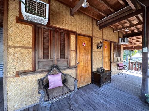 a porch of a house with a bench with a purple pillow at Mount Pinatubo Base Camp at CASA HERMOGINA in Santa Juliana
