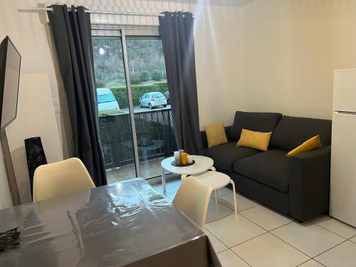 un soggiorno con un divano e un tavolo di Ourea a Savignac-les-Ormeaux