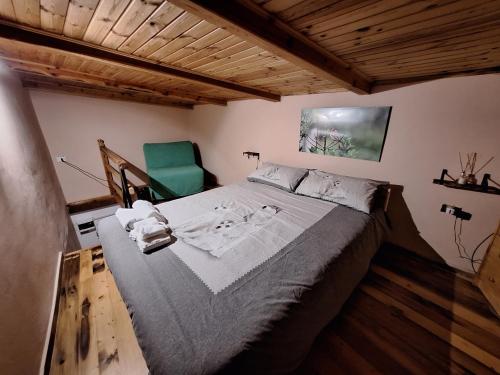 a bedroom with a bed and a green chair at Il Ciabot del Bosco in Frassino