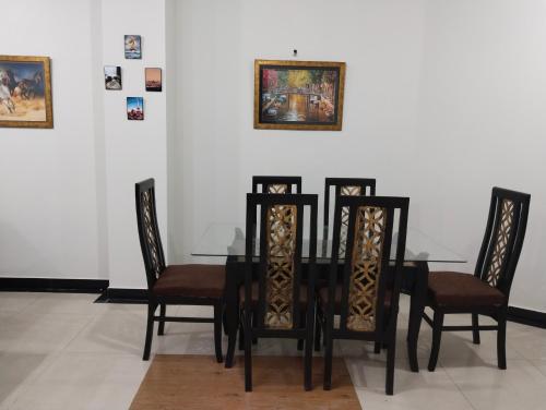 a dining room with a black table and chairs at King's Paradise in Lahore