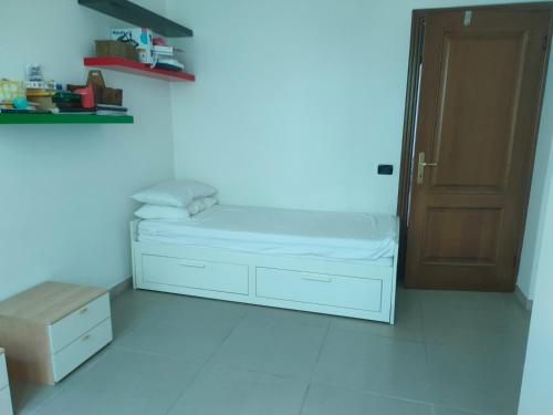 a white room with a bed and a door at Decameron in Borgo a Buggiano