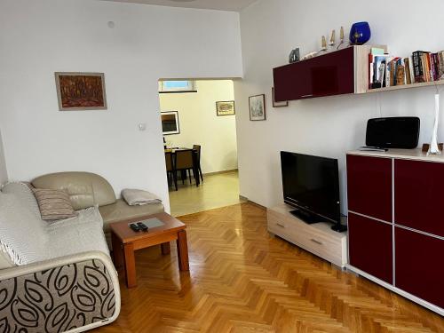 uma sala de estar com um sofá e uma televisão de ecrã plano em Casa del Rey em Sófia