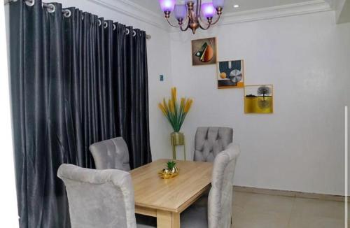 comedor con mesa de madera y sillas en Owtee’s Apartments, en Port Harcourt