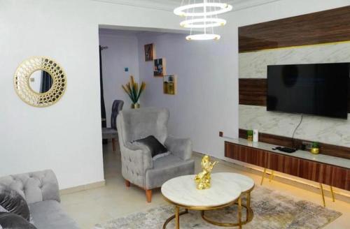 a living room with a couch and a table and a tv at Owtee’s Apartments in Port Harcourt