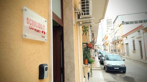 a street with cars parked on the side of a building at sciuliddA Casa Vacanze in Avola
