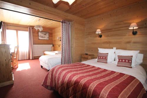 a bedroom with two beds in a log cabin at Hotel La Crémaillère in Le Grand-Bornand