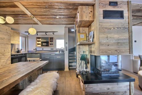 una cocina con paredes de madera y una mesa con un ordenador portátil. en Chalet Topaz - 18 Couchages Sur les Pistes avec Services, en Plagne Villages