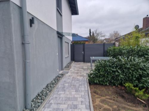 a brick walkway next to a white building at Willi´s Ferienwohnung in Heroldsberg