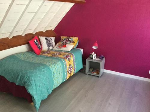 - une chambre avec un lit et un mur violet dans l'établissement Maison Hoëdic, à La Trinité-sur-Mer