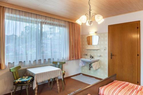 a bathroom with a bed and a table and a sink at Ferienwohnung Dornauer Sommer in Hippach