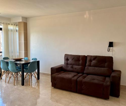 a living room with a brown couch and a table at Sapphire Tower CTC 601-B in Caldas Novas