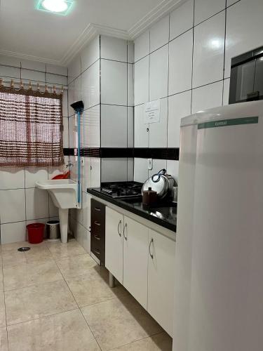 a kitchen with a stove and a sink and a refrigerator at Sapphire Tower CTC 601-B in Caldas Novas