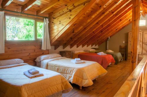 a room with three beds in a log cabin at Aldeas de Vacaciones - Feriendorf in Villa General Belgrano