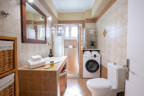 a bathroom with a sink and a washing machine at Lia's Cozy House in Lefkada