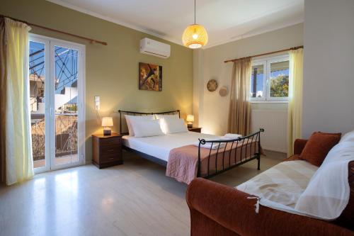 a bedroom with a bed and a couch and a window at Lia's Cozy House in Lefkada