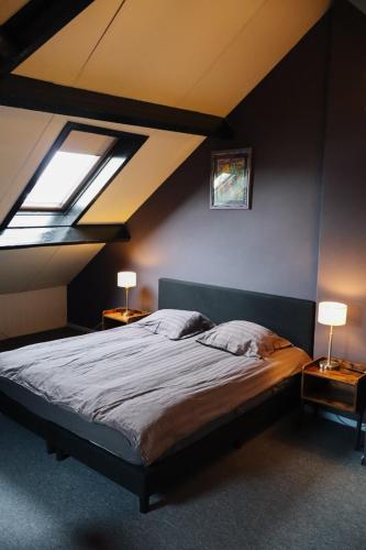 a bedroom with a bed and two lamps on tables at Hotel Brasserie de Kroon in Gulpen