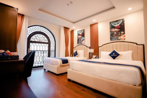 a hotel room with two beds and a window at Sandals Vista Hotel in Bao Loc