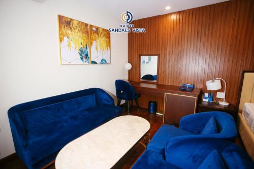 a room with blue furniture and a sign on the wall at Sandals Vista Hotel in Bao Loc