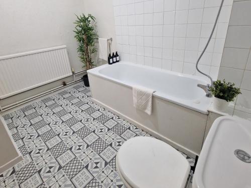 uma casa de banho com uma banheira branca, um WC e um lavatório. em Central location em Londres
