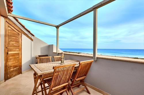 une salle à manger avec une table et des chaises et l'océan dans l'établissement Corallo Beachfront Penthouse by Bobbywashere, à Santa Maria