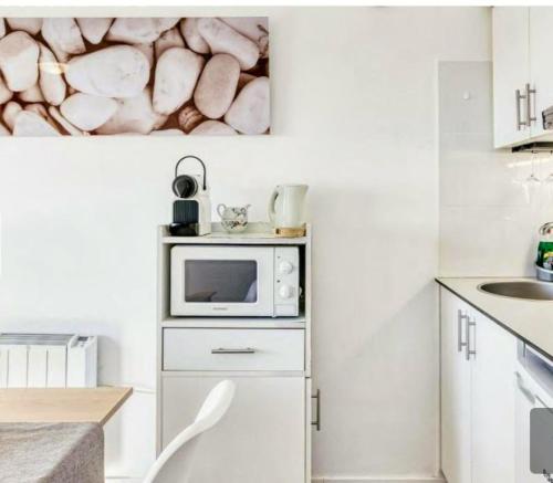 a small kitchen with a microwave and a sink at Modern studio by the lake in Empuriabrava - 30m² - Superb view in Empuriabrava