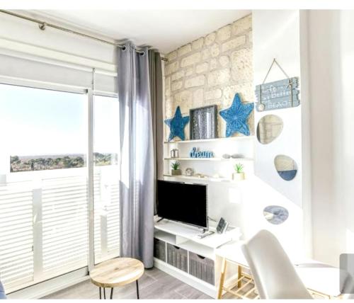 a room with a desk with a tv and stars on the wall at Modern studio by the lake in Empuriabrava - 30m² - Superb view in Empuriabrava