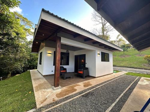 Cette petite maison blanche dispose d'une terrasse. dans l'établissement Cabañas Areno Lodge., à Bijagua